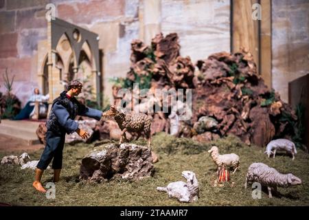 Bamberga, Germania. 29 novembre 2023. Un presepe con un pastore e una pecora. Il presepe è allestito nella cattedrale di Bamberga. Il presepe è usato per rappresentare la storia biblica del Natale. Ciò viene mostrato nelle scene che cambiano settimanalmente. Credito: Daniel Vogl/dpa/Alamy Live News Foto Stock