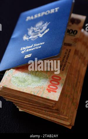 Una pila di 1000 banconote in pesos argentini all'interno di un passaporto degli Stati Uniti.Buenos Aires.Argentina Foto Stock