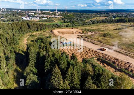 Vista aerea di un paesaggio industriale nel mezzo della natura pittoresca, di una cava di sabbia e di aree industriali con manodopera sullo sfondo Foto Stock