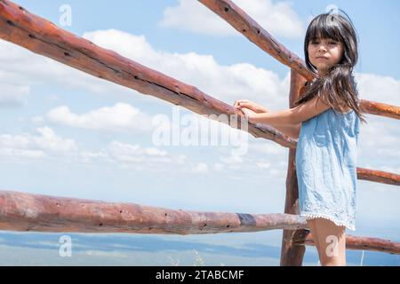 Ritratto di una ragazza turistica vicino a una ringhiera in cima a una catena montuosa a Córdoba, Argentina. Foto Stock