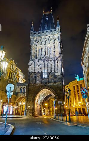 La torre delle polveri gotica medievale, con luci serali da via Celetna, Praga, Cechia Foto Stock
