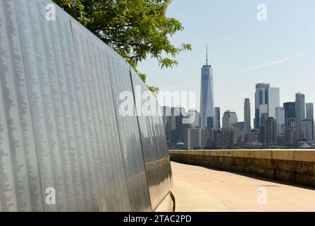 New York, USA - 9 giugno 2018: Il muro d'Onore degli immigrati americani si trova presso l'Ellis Island National Museum e si affaccia sullo skyli di Lower Manhattan Foto Stock