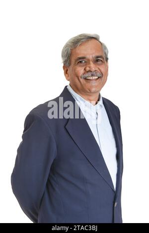 Un uomo d'affari indiano anziano sorridente o dirigente con i capelli grigi in una camicia blu chiaro e una giacca in tuta isolata su bianco Foto Stock