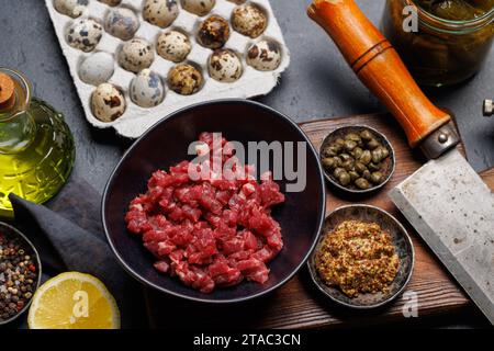 Cottura di una saporita tartare di manzo con cetriolini sottaceto e pane tostato Foto Stock