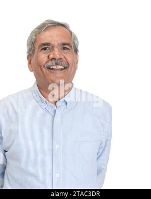 Un uomo d'affari indiano anziano sorridente o dirigente con capelli grigi in una camicia blu chiaro isolata su bianco Foto Stock