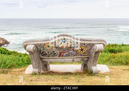 Panca vuota con vista mare - panca decorata con piastrelle a mosaico a colori a Brenton on Sea, Sud Africa Foto Stock
