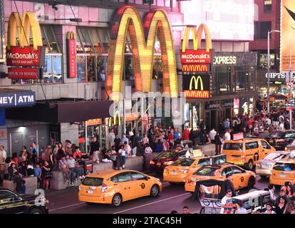 New York, USA - 10 giugno 2018: Persone e taxi gialli vicino al McDonald's a Times Square a New York. Foto Stock