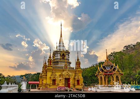 Sonnenstrahlen über dem buddhistischen Tempel Wat Namtok Mae Klang a Ban Luang, Chom Thong, Chiang mai, Thailandia, Asien | raggi del sole su Wat Namto Foto Stock
