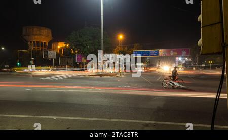 Il traffico stradale cittadino ha una lunga esposizione scattata con sentieri a luce sfocata con l'immagine del segnale di controllo del traffico al mercato sardar ghantaGhar jodhpur raj Foto Stock