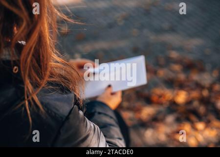 La ragazza apre una busta bianca con un assegno. Assegno retributivo. Tenendo in mano un assegno di stipendio. Donna con stipendio. Foto Stock