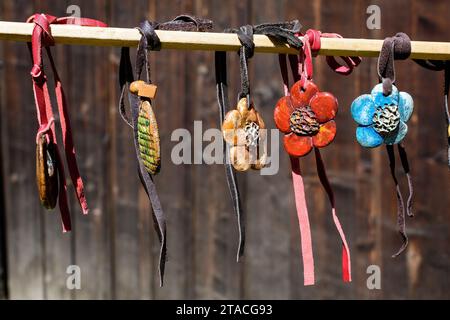 Gruppo di collane colorate dipinte a mano e di souvenir esposti in vendita in un tradizionale mercato del fine settimana a Bucarest, Romania Foto Stock