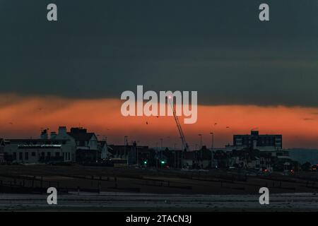 Fuoco su East Worthing e Lancing in una fredda mattinata di novembre giovedì 30 novembre 2023 come visto da Worthing Beach, Worthing. L'alba crea un cielo rosso intenso su East Worthing, Lancing, Shoreham e Hove. Foto Stock