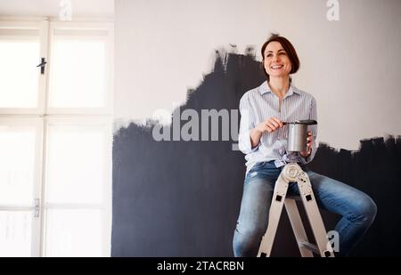 Un Ritratto di giovane donna muro dipinto di nero. Un avvio di piccole imprese. Foto Stock