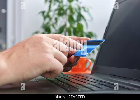 L'uomo fa un acquisto su Internet e punta il dito sul codice cvv. Concetto di pagamento e shopping online. Primo piano Foto Stock