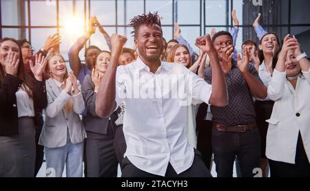 Vista dall'alto di un gruppo di persone multietniche felici che alzano la mano insieme Foto Stock