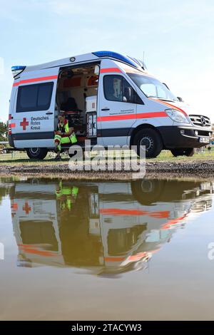 09.09.2023, Magdeburgo, Sachsen-Anhalt, GER - Sanitaeterin sitzt in einem Krankenwagen und wartet auf einen Einsatz. 112, Alltag, Ambulanz, aussen, Aussenaufnahme, Beruf, deutsch, Deutsches Rotes Kreuz, Deutschland, Erste Hilfe, Europa, europaeisch, Fahrzeug, Frau, Gesellschaft, Helferin, HF, Hilfe, Hochformat, lavoro, Krankenwagen, Magdeburg, Mensch, Not, Notarzt, Notarztwagen, Notdienst, Notfall, Nothelferin, Nothilfe, Notruf, Person, PKW, Retterin, Rettung, Rettungsdienst, Rettungsdienstwagen, Rettungswagen, Rettungswesen, RTW, Sachsen-Anhalt, SEE, spiegeln, Spiegelung, Teich, Warten, Wartezeit Foto Stock