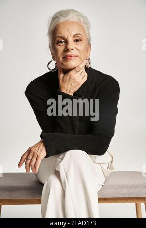 ritratto d'affari, felice donna d'affari di mezza età in un elegante abbigliamento informale seduta sulla panca interna Foto Stock