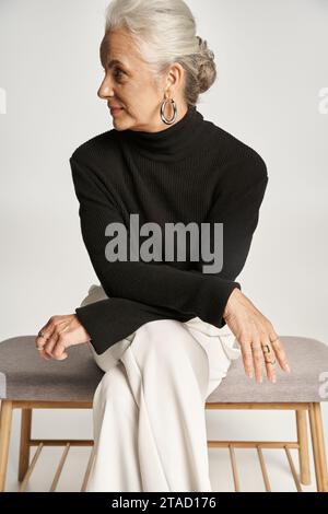 ritratto di lavoro, felice donna d'affari di mezza età in un elegante abbigliamento informale seduta su una panca interna Foto Stock