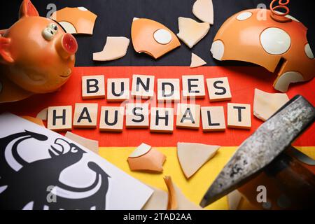 Banca di maialini schiacciata sulla bandiera tedesca con scritte sul bilancio federale Foto Stock