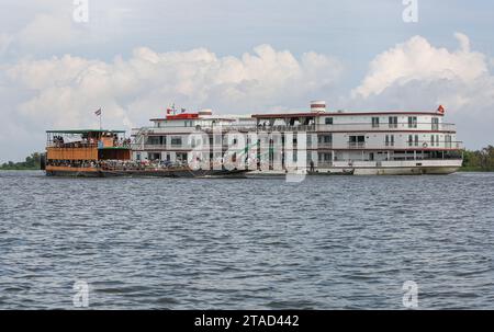 Il traghetto cambogiano trasportava passeggeri Khmer e veicoli sul fiume Tonle SAP vicino alla lussuosa nave da crociera Mekong Jahan (Heritage Line), Cambogia, Asia Foto Stock