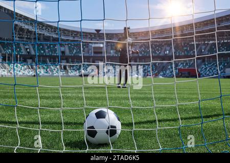 il giocatore di calcio calcia la palla nel gol dello stadio Foto Stock