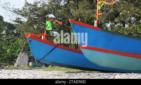 Variopinte barche da pesca parcheggiate sulla spiaggia di Alappuzha, Kerala, India. Foto Stock