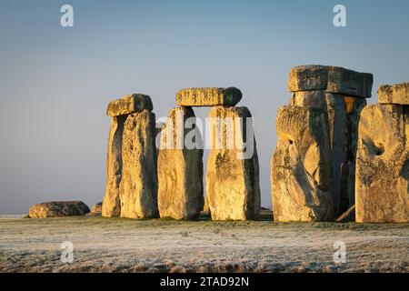 La luce del sole del mattino splende sulle Sarsen Stones di Stonehenge, Stonehenge, Wiltshire, Inghilterra. Inverno (gennaio) 2022. Foto Stock