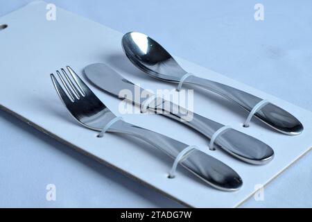 forchette cucchiai e coltelli utensili da mangiare sono disposti in modo ordinato in una confezione di pannelli di carta Foto Stock