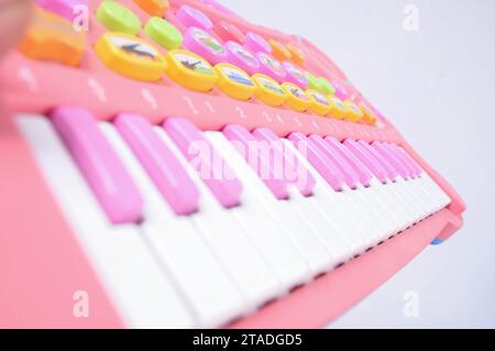 Una vista ravvicinata di un pianoforte giocattolo rosa per bambini con tasti ben allineati e uno sfondo isolato Foto Stock