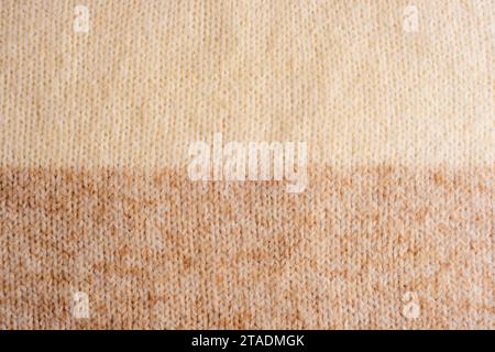 Maglione in maglia di lana beige e marrone, texture, sfondo. Foto Stock