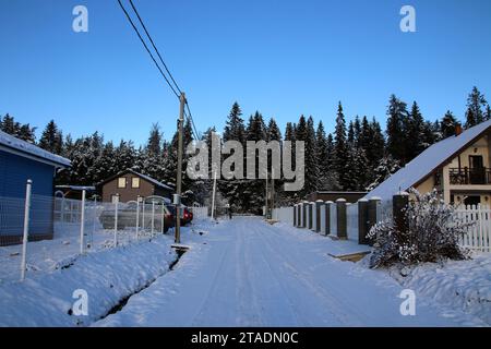 Leningrado, Russia. 19 novembre 2023. La neve ha coperto la strada e le case del villaggio dopo una forte nevicata nella regione di Leningrado. (Immagine di credito: © Maksim Konstantinov/SOPA Images via ZUMA Press Wire) SOLO USO EDITORIALE! Non per USO commerciale! Foto Stock