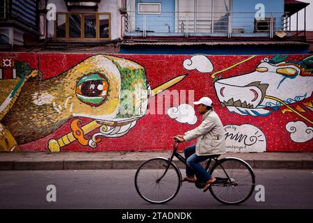 Un uomo passa il mosaico di 1000 anni ad Hanoi, in Vietnam Foto Stock