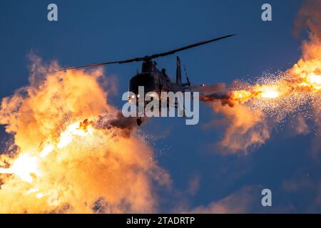 Elicottero militare in volo che spara fuori di flare decoy di notte. Foto Stock