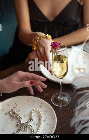 primo piano delle mani delle donne che cercano un bicchiere di vino. Foto Stock