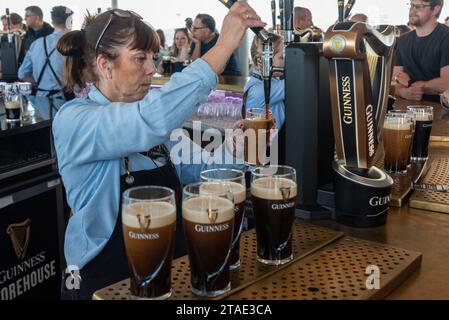 Repubblica d'Irlanda, Contea di Dublino, Dublino, Guinness Storehouse, museo in fabbrica che ripercorre la storia della famosa birra irlandese, donna che tira una pinta Foto Stock