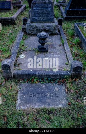 Ingresso con lastre di pietra al caveau nel cimitero vittoriano coperto di erba del Galles. Concetto - morte, famiglia, sepoltura, sotterraneo, tomba. Foto Stock