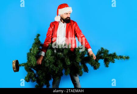 Buon Natale e felice anno nuovo. Festeggiamenti invernali. Addetto alla consegna con cappello di Babbo Natale e cappotto rosso con albero di Natale. Babbo Natale con Foto Stock