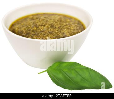 Foglie di basilico fresco con pesto in un recipiente Foto Stock