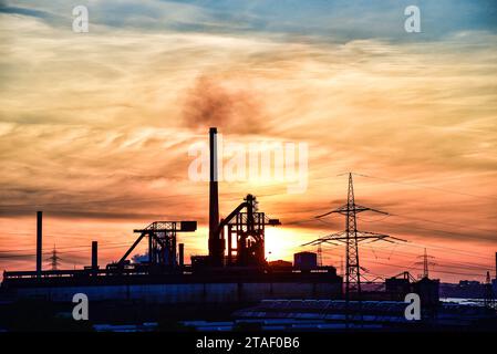 Paesaggio industriale con camini e linee elettriche nella zona della Ruhr al tramonto, Renania settentrionale-Vestfalia, Germania, Europa Foto Stock