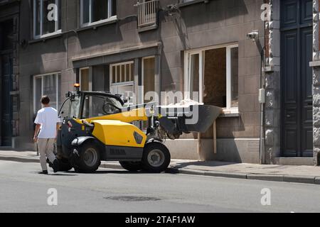 Le macerie dei lavori di ristrutturazione degli appartamenti vengono raccolte nel secchio di una piccola macchina da costruzione. Foto Stock