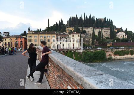 Verona, 7 giugno 2017: Persone al ponte pietra e Castel San Pietro sullo sfondo, Verona, Italia Foto Stock