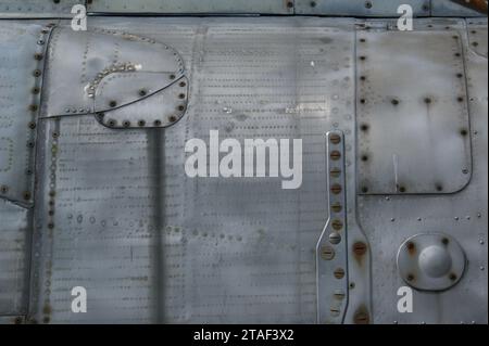 Sfondo metallico con viti e rivetti. Un frammento della fusoliera. Foto Stock