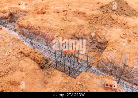 Lo scavo di trincee è in fase di preparazione per il versamento di calcestruzzo sulle fondamenta Foto Stock