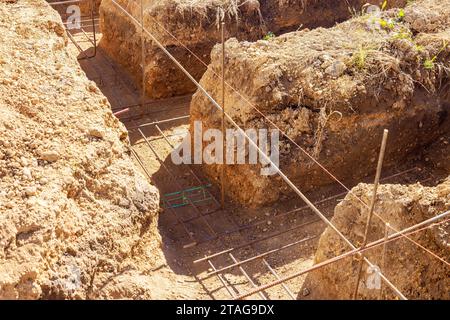 Costruzione di fondamenta in calcestruzzo da scavo di una trincea di terra Foto Stock