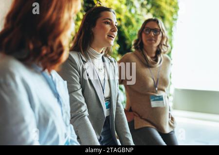 Professionisti impegnati in una discussione aziendale produttiva durante un evento. Colleghi in rete e collaborazioni, esemplificando un lavoro di squadra efficace. Dyna Foto Stock