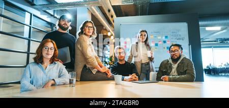 Ritratto di un team aziendale eterogeneo in un'azienda tecnologica che guarda la fotocamera. Mostrano lavoro di squadra e dedizione. Un team multiculturale sembra fiducioso Foto Stock