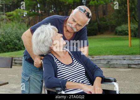 uomo e donna anziana su una sedia a rotelle Foto Stock