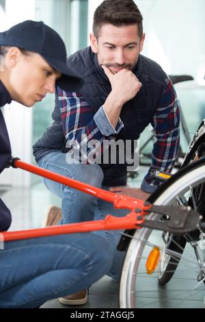 donna che usa tagliabulloni in bicicletta Foto Stock