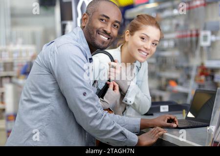 ragazza con un consulente in piedi vicino al bancone con un portatile Foto Stock