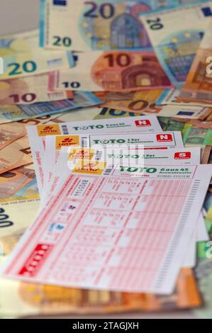 Totoschein auf Geldscheinen. In Deutschland betreibt der Deutsche lotto- und Totoblock als Zusammenschluss der Landes-Lotteriegesellschaften das Lottospiel. Lotto ist ein Glücksspiel, bei dem der Spieler gegen einen finanziellen Einsatz auf das Ziehen vorher getippter Zahlen aus einer begrenzten Zahlenmenge setzt. Symbolfoto, Themenfoto *** biglietto della lotteria sulle banconote in Germania, il lotto tedesco e Totoblock, un'associazione di compagnie di lotteria statali, gestisce il gioco della lotteria lotto è un gioco d'azzardo in cui il giocatore scommette sull'estrazione di numeri precedentemente selezionati da un set limitato Foto Stock